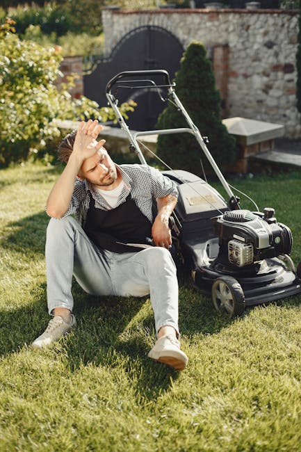 A gardener from Gardeners Winchmore Hill is performing hedge trimming in an outdoor garden scene. The gardener, wearing a dark long-sleeved top and a grey cap, is using long-handled hedge shears to ca